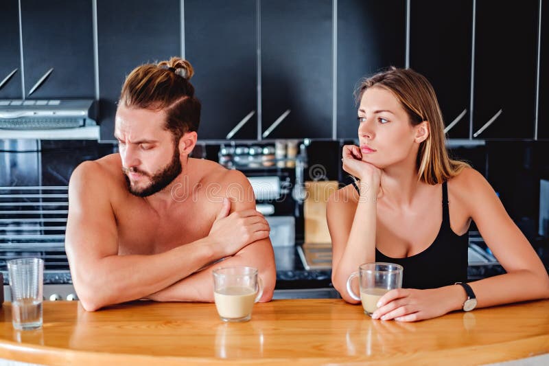 Coppia la conversazione mentre si siedono nella cucina fotografia stock libera da diritti Coppia la conversazione mentre si siedono nella cucina fotografia stock libera da diritti