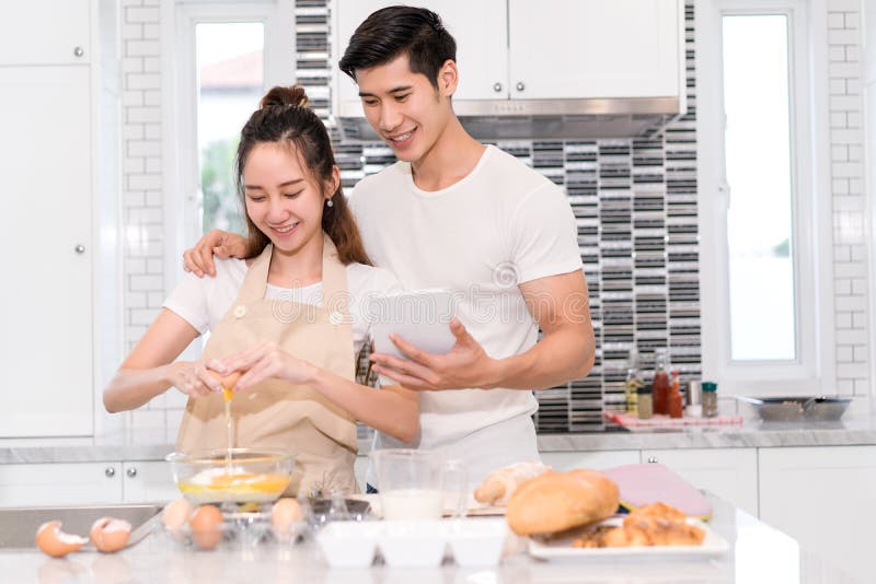 Coppia la fabbricazione il forno, il dolce nella stanza della cucina, il giovane uomo asiatico e della donna fotografie stock libere da diritti Coppia la fabbricazione il forno, il dolce nella stanza della cucina, il giovane uomo asiatico e della donna fotografie stock libere da diritti