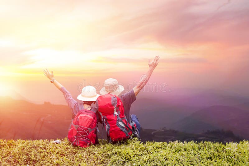 Coppia lo zaino che gode del tramonto sul picco della montagna nebbiosa immagine stock libera da diritti Coppia lo zaino che gode del tramonto sul picco della montagna nebbiosa immagine stock libera da diritti