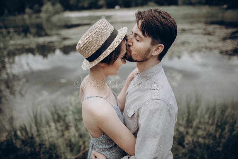 Coppie alla moda dei pantaloni a vita bassa che baciano nel lago abbraccio della donna e dell'uomo, immagini stock Coppie alla moda dei pantaloni a vita bassa che baciano nel lago abbraccio della donna e dell'uomo, immagini stock