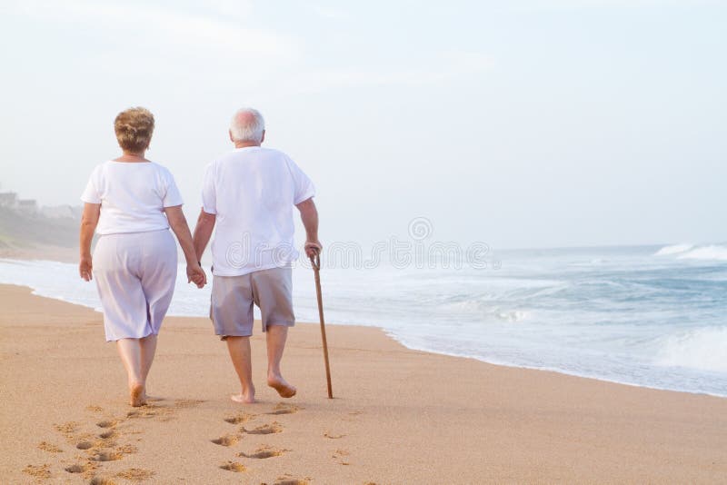 Coppie anziane che camminano sulla spiaggia