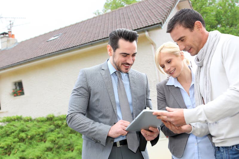 Real-estate-agent showing house plan on digital tablet. Real-estate-agent showing house plan on digital tablet