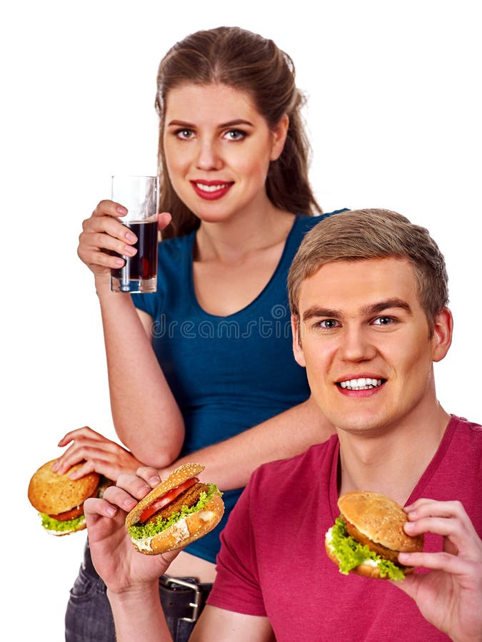 Coppie che mangiano alimenti a rapida preparazione Hamburger dell'ossequio della donna e dell'uomo fotografie stock libere da diritti Coppie che mangiano alimenti a rapida preparazione Hamburger dell'ossequio della donna e dell'uomo fotografie stock libere da diritti