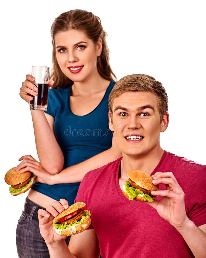 Coppie che mangiano alimenti a rapida preparazione Hamburger dell'ossequio della donna e dell'uomo fotografia stock libera da diritti Coppie che mangiano alimenti a rapida preparazione Hamburger dell'ossequio della donna e dell'uomo fotografia stock libera da diritti