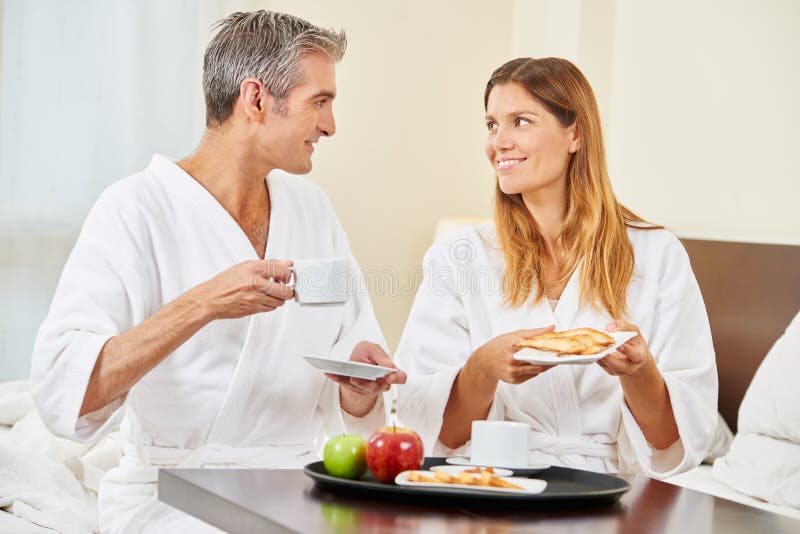 Coppie che mangiano prima colazione nella camera di albergo immagini stock libere da diritti Coppie che mangiano prima colazione nella camera di albergo immagini stock libere da diritti