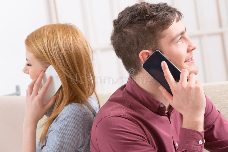 Coppie che parlano sui loro smartphones immagini stock libere da diritti Coppie che parlano sui loro smartphones immagini stock libere da diritti