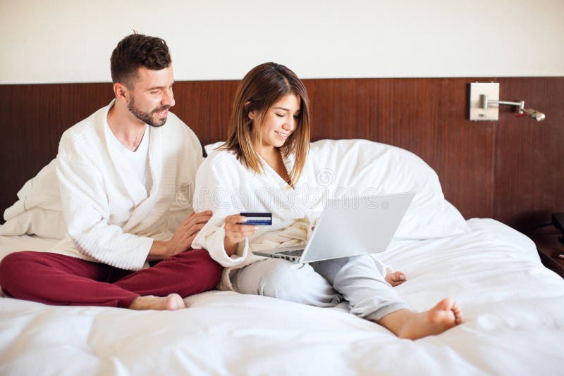 Coppia che prenota un tour con un laptop immagine stock