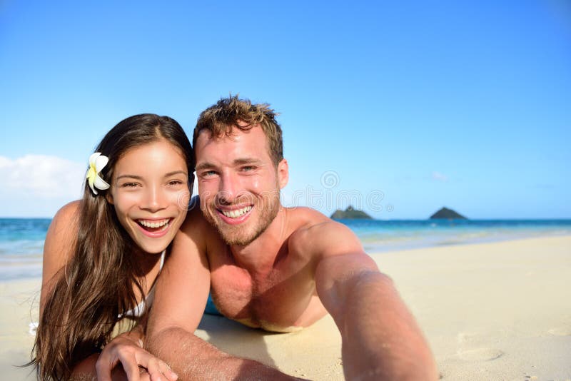 Coppie che si rilassano sulla spiaggia che prende l'immagine del selfie immagini stock Coppie che si rilassano sulla spiaggia che prende l'immagine del selfie immagini stock