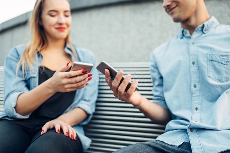 Coppie della persona dedita del telefono che considerano gli smartphones immagine stock libera da diritti Coppie della persona dedita del telefono che considerano gli smartphones immagine stock libera da diritti