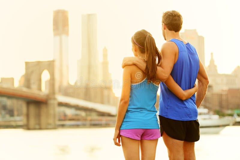 Coppie di forma fisica che si rilassano dopo avere corso a New York immagini stock libere da diritti Coppie di forma fisica che si rilassano dopo avere corso a New York immagini stock libere da diritti
