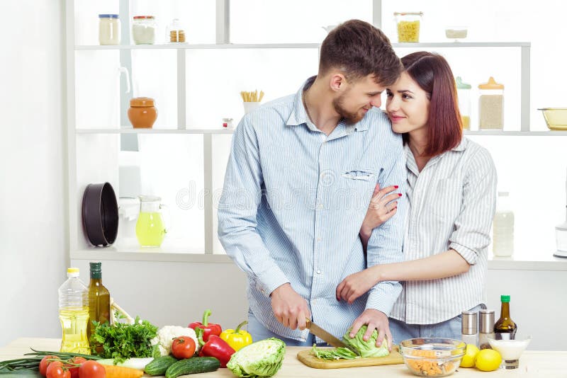 Coppie felici amorose che preparano insalata sana degli ortaggi freschi in cucina fotografie stock libere da diritti Coppie felici amorose che preparano insalata sana degli ortaggi freschi in cucina fotografie stock libere da diritti