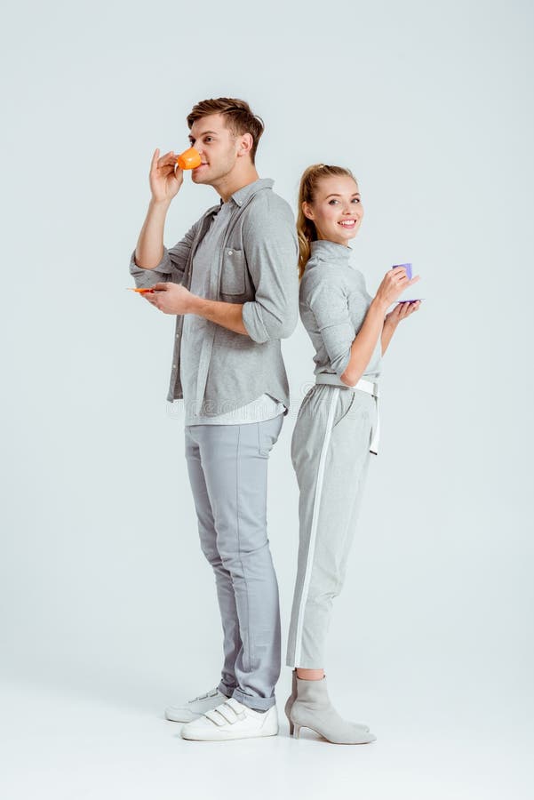 coppie felici in caffè bevente dell'abbigliamento grigio fotografia stock coppie felici in caffè bevente dell'abbigliamento grigio fotografia stock