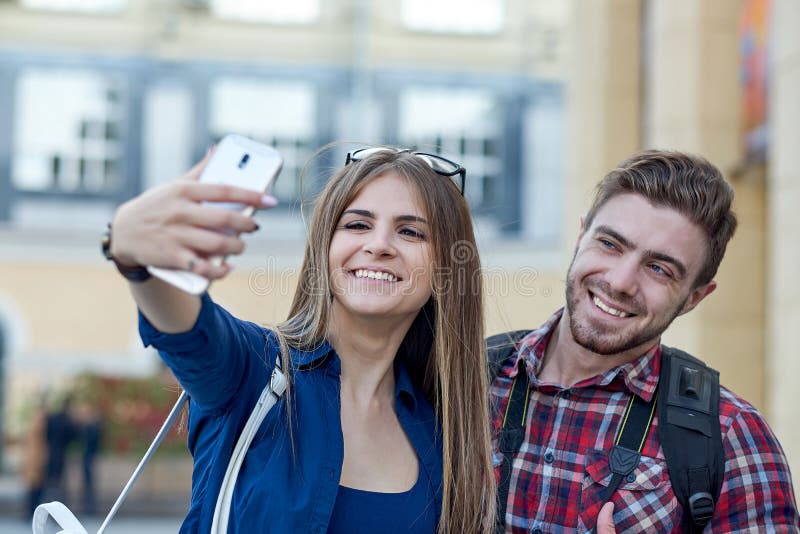 Coppie felici dei turisti che prendono selfie in attrazione della città