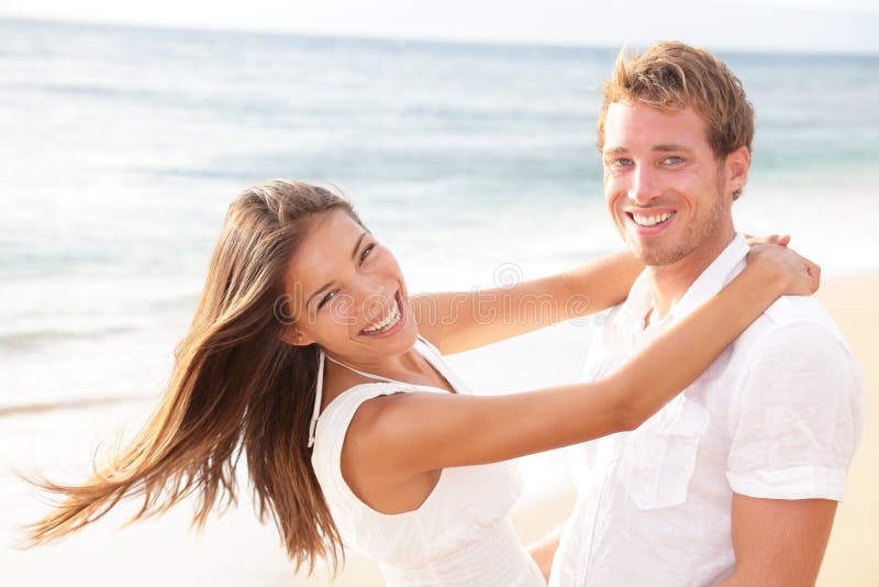 Coppie felici sulla spiaggia nel divertiresi di amore fotografie stock libere da diritti Coppie felici sulla spiaggia nel divertiresi di amore fotografie stock libere da diritti