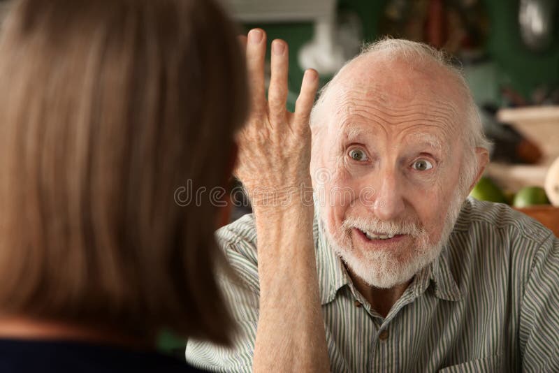 Senior couple at home in kitchen focusing on angry man. Senior couple at home in kitchen focusing on angry man