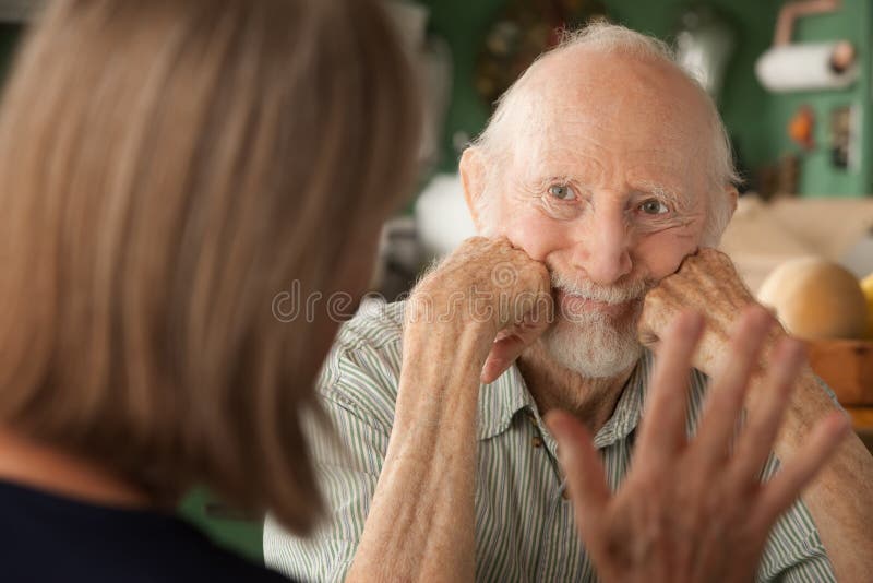 Senior couple at home in kitchen focusing on angry man. Senior couple at home in kitchen focusing on angry man