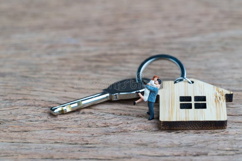 Coppie miniatura di felicità della gente che stanno con la catena chiave della casa fotografia stock Coppie miniatura di felicità della gente che stanno con la catena chiave della casa fotografia stock