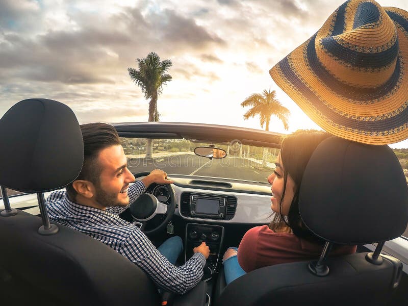 Coppie ricche d'avanguardia divertendosi conducendo automobile convertibile al tramonto - amanti romantici felici che godono del fotografie stock libere da diritti Coppie ricche d'avanguardia divertendosi conducendo automobile convertibile al tramonto - amanti romantici felici che godono del fotografie stock libere da diritti