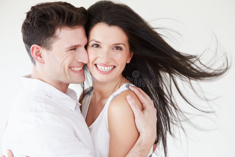 Coppie romantiche che abbracciano contro il fondo bianco dello studio immagini stock libere da diritti Coppie romantiche che abbracciano contro il fondo bianco dello studio immagini stock libere da diritti