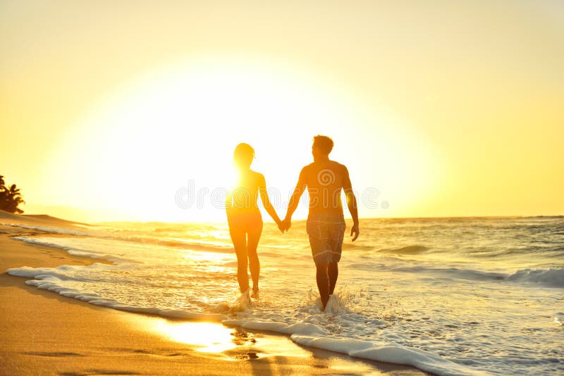 Coppie romantiche di luna di miele nell'amore al tramonto della spiaggia