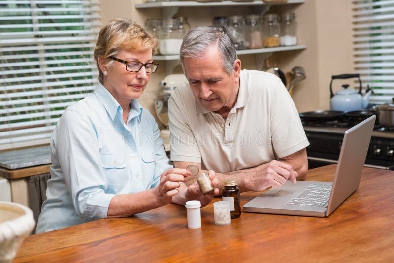 Coppie senior che cercano farmaco online immagine stock Coppie senior che cercano farmaco online immagine stock