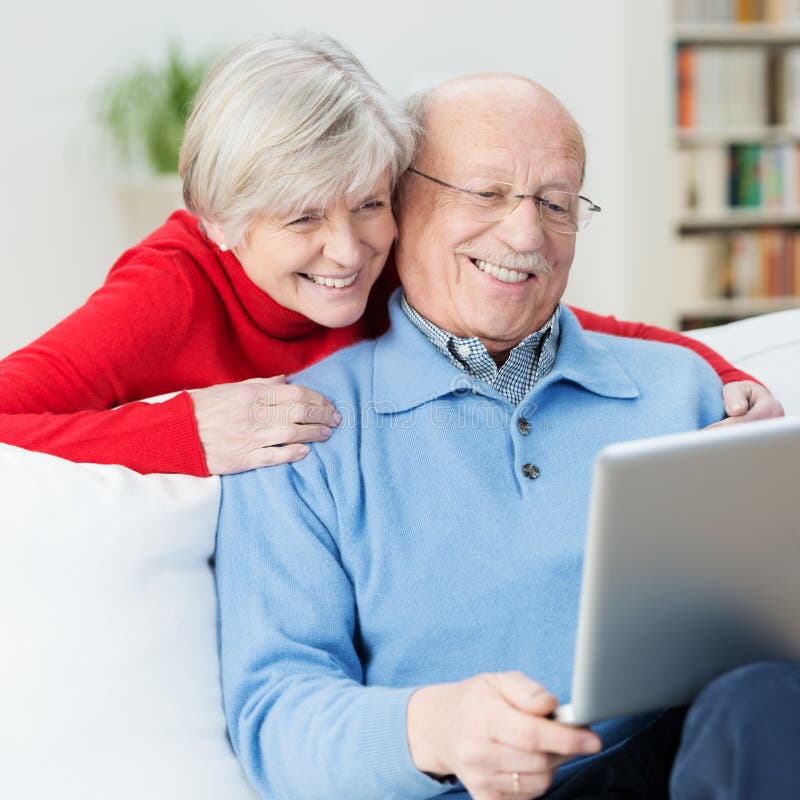 Coppie senior divertenti facendo uso di un computer portatile fotografie stock Coppie senior divertenti facendo uso di un computer portatile fotografie stock