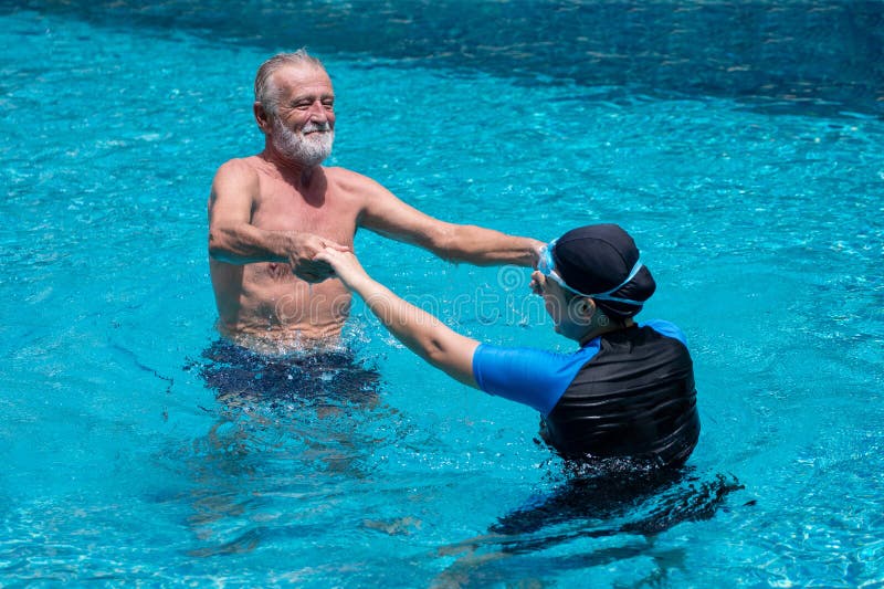 Coppie senior felici che ballano insieme nella piscina Avere divertimento Insegnante di nuoto Tenersi per mano, addestramento, pe fotografia stock Coppie senior felici che ballano insieme nella piscina Avere divertimento Insegnante di nuoto Tenersi per mano, addestramento, pe fotografia stock