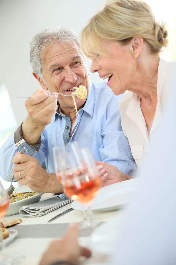 Coppie senior felici che dividono cena fotografie stock Coppie senior felici che dividono cena fotografie stock