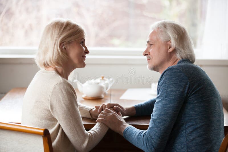Coppie senior sensuali che si tengono per mano sguardo negli occhi fotografie stock libere da diritti Coppie senior sensuali che si tengono per mano sguardo negli occhi fotografie stock libere da diritti