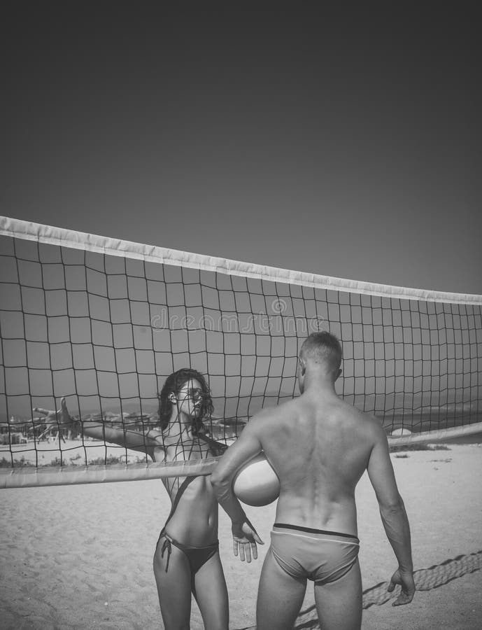 Coppie sexy Le coppie attive sportive giovani stanno la rete vicina di pallavolo, gioco del gioco il giorno di estate Le coppie s fotografie stock libere da diritti Coppie sexy Le coppie attive sportive giovani stanno la rete vicina di pallavolo, gioco del gioco il giorno di estate Le coppie s fotografie stock libere da diritti