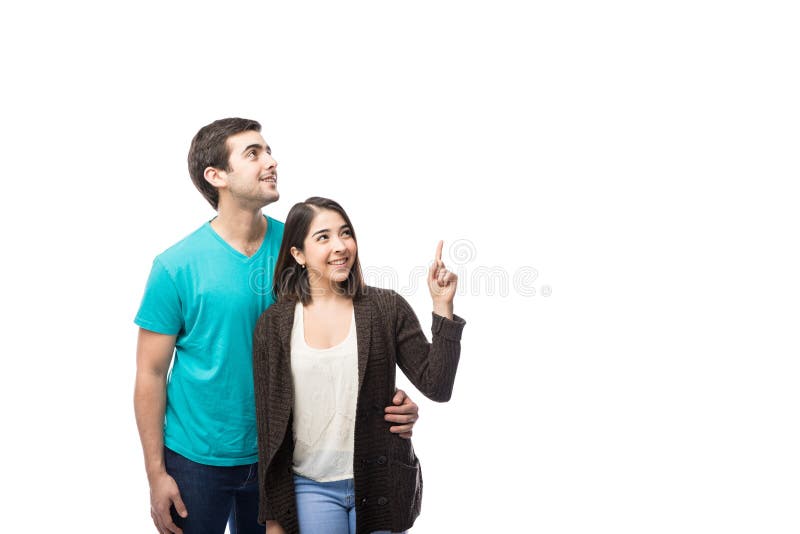 Coppie sveglie che guardano e che indicano su fotografia stock