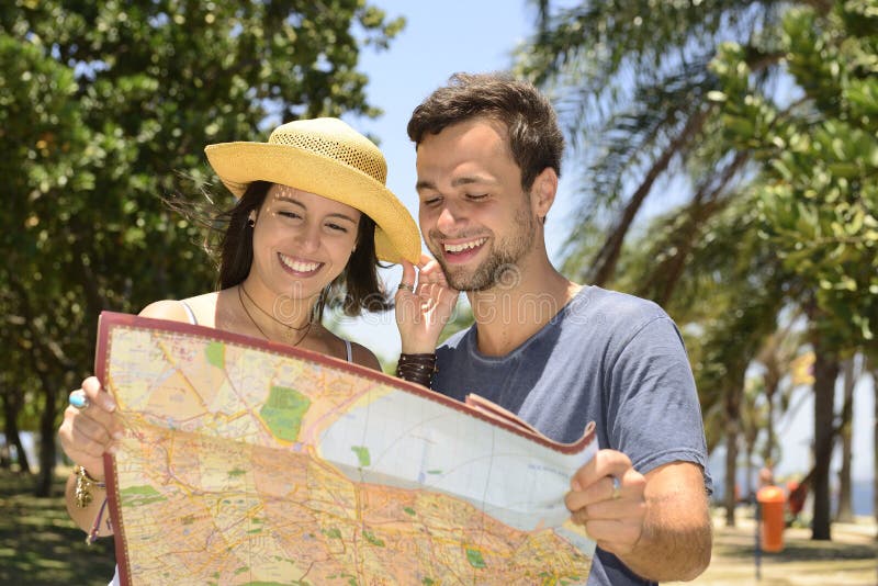 Coppie turistiche felici con la mappa immagine stock libera da diritti Coppie turistiche felici con la mappa immagine stock libera da diritti