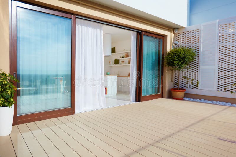 Copra il patio superiore con la cucina dello spazio aperto, i portelli scorrevoli ed il decking sul piano superiore immagine stock Copra il patio superiore con la cucina dello spazio aperto, i portelli scorrevoli ed il decking sul piano superiore immagine stock