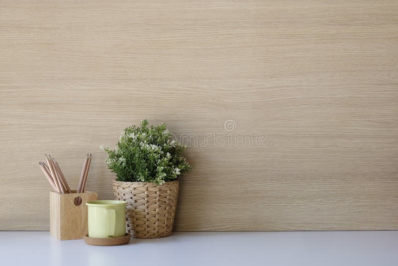 Copy space Mockup workspace with coffee, pencil and plant on desk and wood wall.