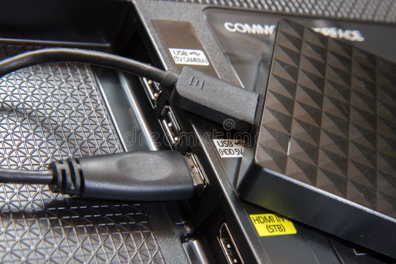 The portable drive is plugged into a slot in the back of the TV. Close-up view of copying data from the television.