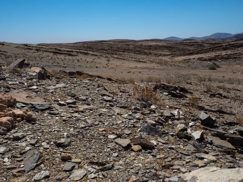 Copyspace de la vida dura que mostraba la montaña de la roca secó la tierra polvorienta del paisaje del desierto de Namib con los foto de archivo Copyspace de la vida dura que mostraba la montaña de la roca secó la tierra polvorienta del paisaje del desierto de Namib con los foto de archivo