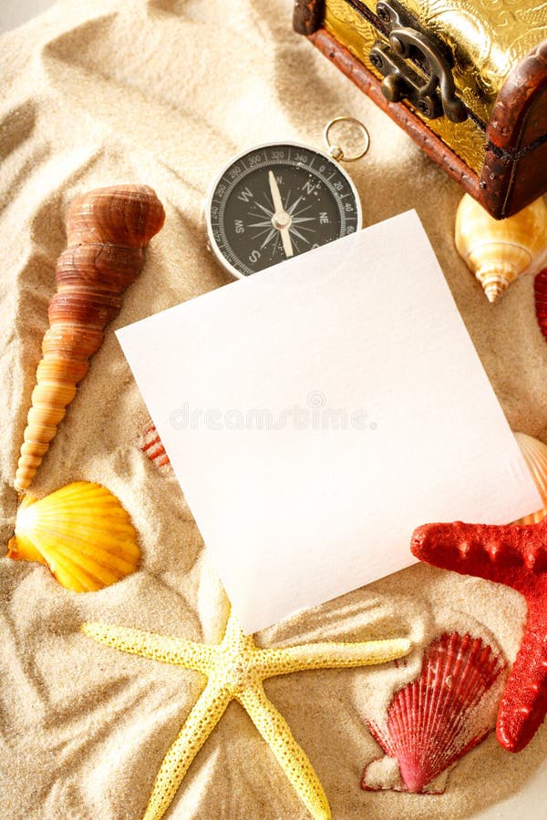 Coquillages, boussole et papier sur le sable photographie stock Coquillages, boussole et papier sur le sable photographie stock
