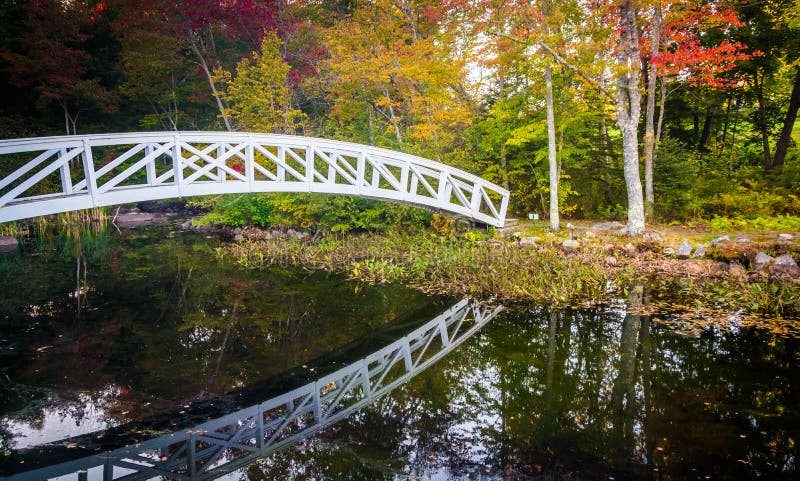 Cor do outono e ponte de passeio sobre uma lagoa em Somesville, Maine fotos de stock Cor do outono e ponte de passeio sobre uma lagoa em Somesville, Maine fotos de stock
