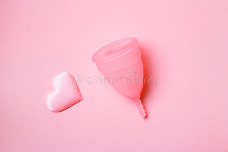 Copo menstrual branco com corações vermelhos simbolizando a menstruação em  rosa