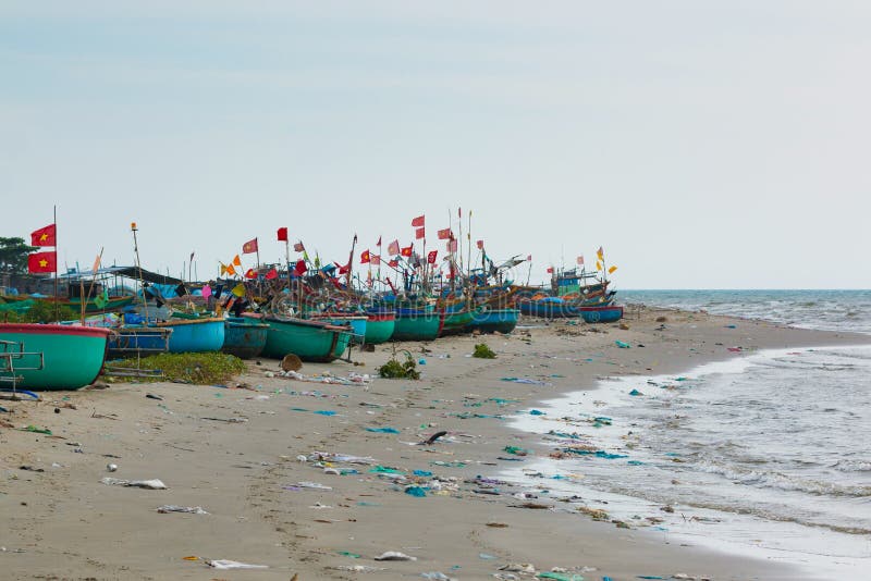 Coracles vietnamianos tradicionais da pesca na praia poluída em uma aldeia piscatória em Vietname imagens de stock royalty free