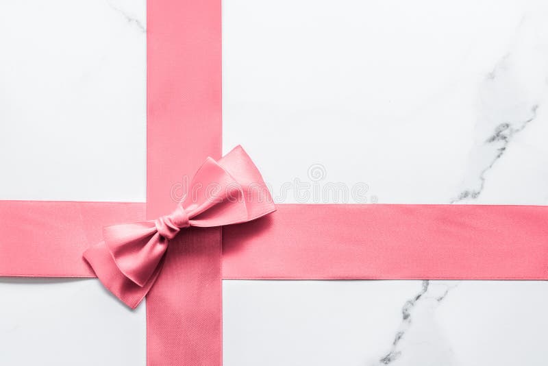Pink silk ribbon and bow on marble background, girl baby shower present and  glamour fashion gift decor for luxury beauty brand, holiday flatlay design, Stock image