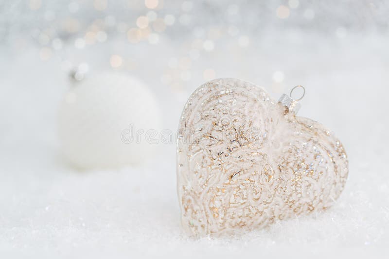 Coraz?n de cristal en una nieve Fondo blanco borroso del bokeh que brilla con las luces que brillan intensamente Decoraci?n de la fotografía de archivo Coraz?n de cristal en una nieve Fondo blanco borroso del bokeh que brilla con las luces que brillan intensamente Decoraci?n de la fotografía de archivo