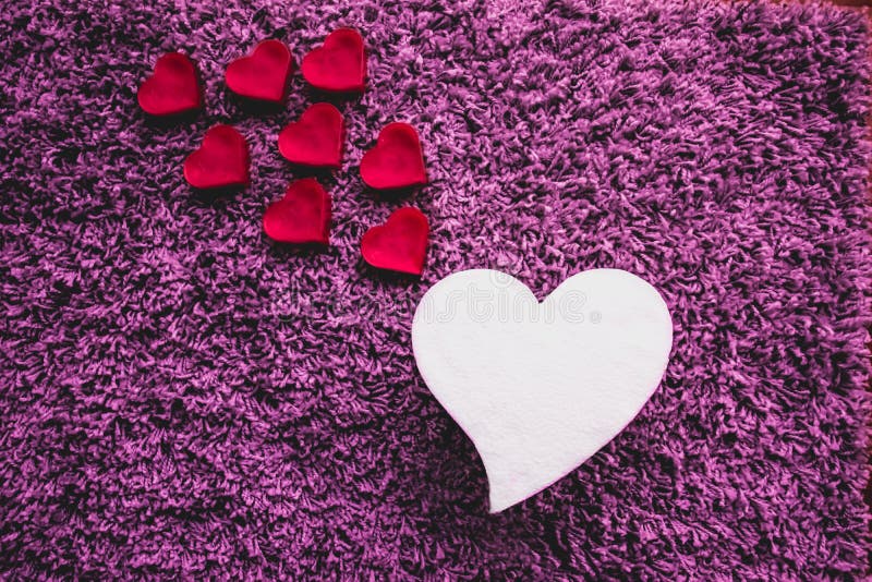 Corazón blanco grande con corazones rosados más pequeños que suben Fondo púrpura foto de archivo libre de regalías Corazón blanco grande con corazones rosados más pequeños que suben Fondo púrpura foto de archivo libre de regalías