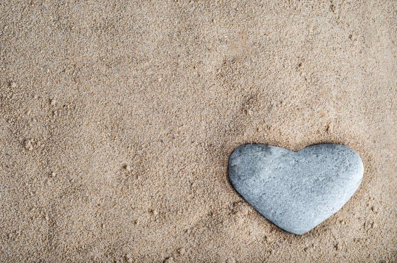 Corazón de piedra en arena fotografía de archivo Corazón de piedra en arena fotografía de archivo