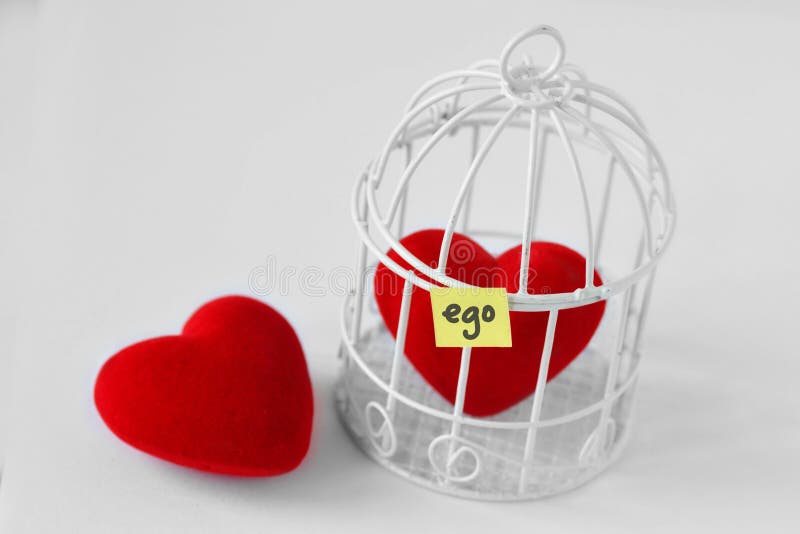 Free heart and heart in a bird cage with the word Ego written on paper note White background - Love and freedom concept. Free heart and heart in a bird cage with the word Ego written on paper note White background - Love and freedom concept