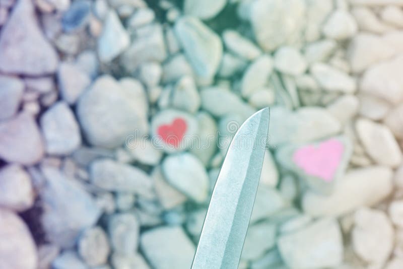 Corazón rosado que se zambulle del cuchillo de corte pintado con la barra de labios en el pedazo o fotos de archivo libres de regalías Corazón rosado que se zambulle del cuchillo de corte pintado con la barra de labios en el pedazo o fotos de archivo libres de regalías