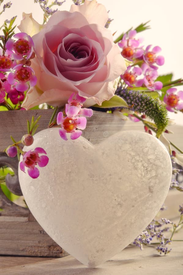 A decorative, heart-shaped object and pretty pink flowers for a wedding or valentines. A decorative, heart-shaped object and pretty pink flowers for a wedding or valentines.