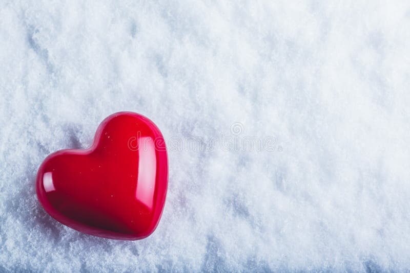 Coração lustroso vermelho em um fundo branco gelado da neve Amor e conceito do Valentim do St