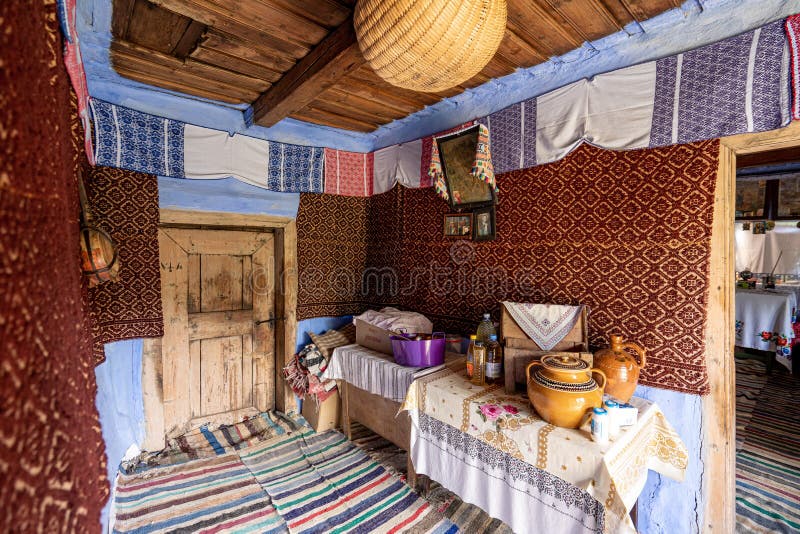 Corbi, Romania - July 2019: traditional peasants house interior well preserved with authentic carpets, clothing and personal items