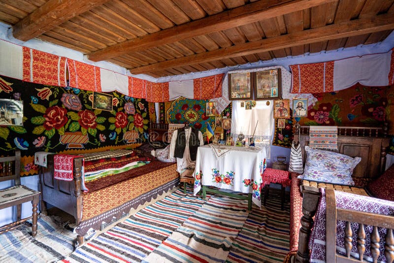 Corbi, Romania - July 2019: traditional peasants house interior well preserved with authentic carpets, clothing and personal items